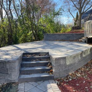 Terraced retaining walls installed to create usable space on sloped side yard in Franklin, WI. Walls made of County Materials Integrity block (silvertone color). 