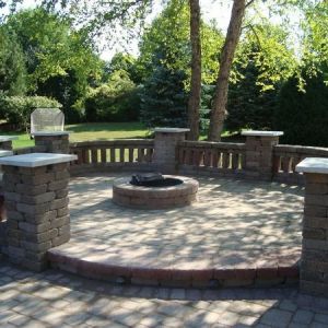 Pillars and slotted seat walls installed around fire pit space in Mount Pleasant made of County Materials Summit Stone.