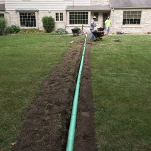 Workers buried the sump pump discharge and trenched 4 inch SDR-35 to rear of yard, away from foundation. Work performed in Mount Pleasant, WI.