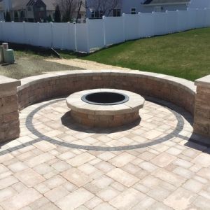 A circle fire pit and seat wall made of Unilock Olde Quarry block in Sturtevant.