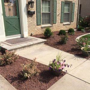 After image: Crushed red granite beds with paver edging are added. Colors are picked that will complement the home. 