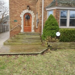 Before image: Old timber wall and steps with overgrown shrubs look dated at this home in Racine.