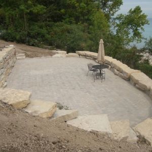 An picturesque patio is installed between the terraced outcropping stone sea walls.