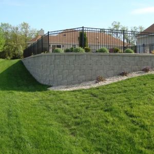 Slopes in the yard would have made installing a pool difficult. Adding a retaining wall helps level area for pool.