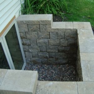 StoneWall block is installed for an egress window retaining wall around a basement window.