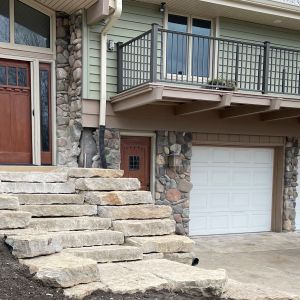 Rustic gold natural cut stone steps leading to entrance.