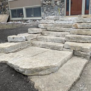 Large quarry cut Rustic Gold pieces create steps and terraced wall leading to front entrance.