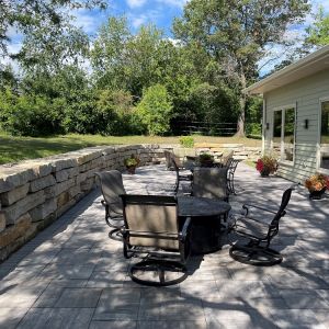 Rustic Gold Outcropping stone retaining wall installed along edge of patio in Caledonia