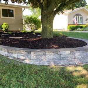 Tree retaining wall installed in Caledonia, WI using County Materials Tribute block (silvertone color).