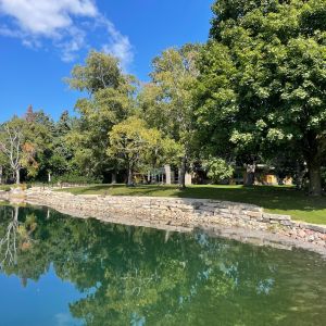 Heavy, rustic gold Lannon outcropping stone and granite rip-rap boulders contain the soil to prevent erosion along a pond in Mount Pleasant.