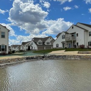 Rustic gold outcropping stone retaining walls installed to prevent shoreline erosion at ponds in Mount Pleasant, WI