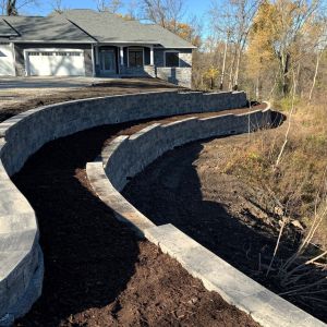 Large scale, two-tiered block retaining wall installed in Caledonia, WI using County Materials Integrity block (silvertone color).
