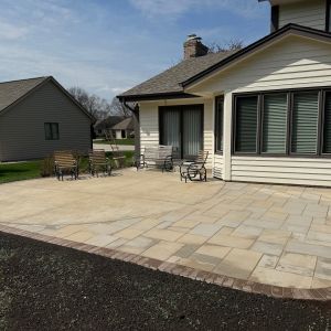 Paver patio extension off existing concrete patio in Mount Pleasant, WI using County Materials Grand Discover pavers (intension color) with beckon colored border.