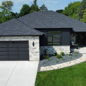 New construction landscaping in Mount Pleasant, WI. New sod, plantings, gray slate decorative stone and Fond Du Lac flagstone walkway.